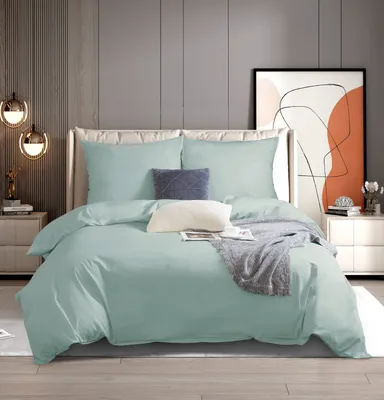 A neatly made bed with mint green bedding in a modern bedroom setting.