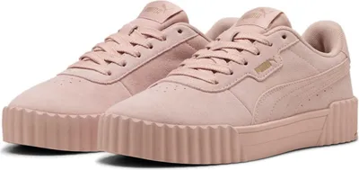 A pair of pink Puma Carina sneakers shown from a diagonal front view against a white background.
