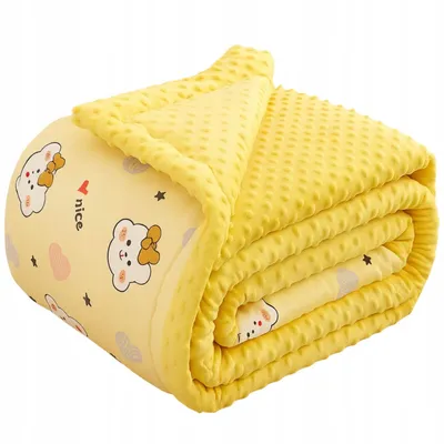 A folded yellow baby blanket with a cute bear pattern.