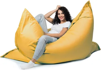 A woman is sitting on a large yellow beanbag chair.
