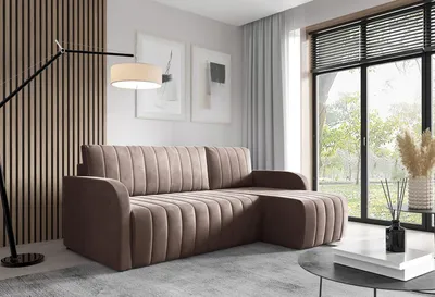 A modern living room with a sectional sofa, floor lamp, and large window.