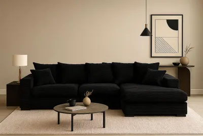 A black sectional sofa is shown in a minimalist living room setting.