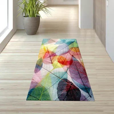 A colorful rug with a leaf pattern is placed on a wooden floor in a hallway.