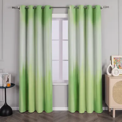 A pair of green and white gradient curtains hanging in front of a window.