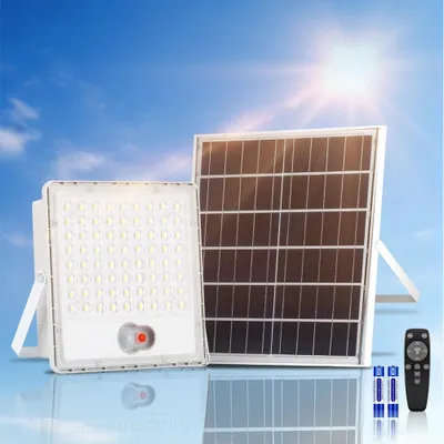 A solar-powered floodlight and solar panel are displayed against a bright blue sky with a sunburst.