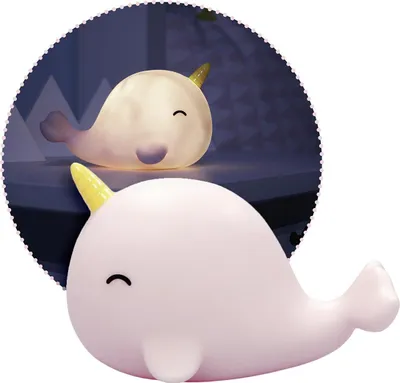 A close-up of a pink narwhal-shaped night light in the foreground, with a glowing white narwhal night light in the background, set against a dark, slightly blurred background with mountain shapes.