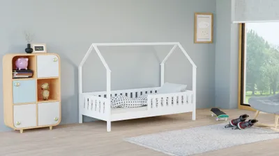 A child's bedroom with a white house-shaped bed, a wooden cabinet, and a window overlooking trees.