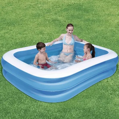 A family enjoying a swim in an inflatable pool on a grassy lawn.