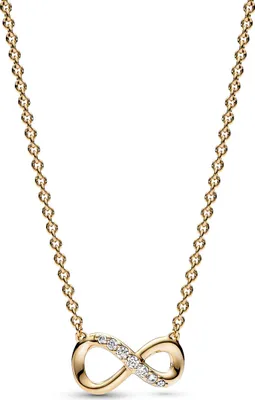 A close-up studio shot of a gold-colored infinity necklace with small clear stones.