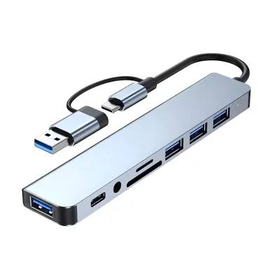 A silver USB-C hub with multiple ports and cables is shown against a white background.