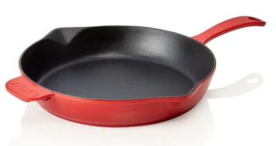 A red cast iron frying pan with a black interior is shown on a white background.