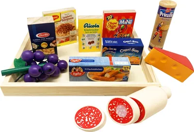 A collection of toy food items arranged on a wooden tray, with additional items placed around it.