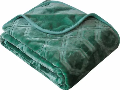 A folded green blanket with a geometric pattern.