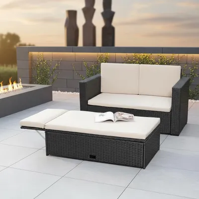 An outdoor patio setting with rattan furniture and a fire pit.