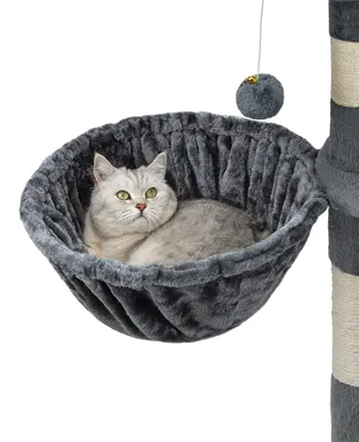 A cat is resting in a gray hammock attached to a cat tree.