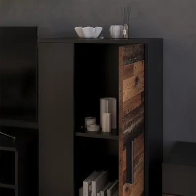 A close-up view of a black cabinet with a rustic wood-paneled door slightly ajar, revealing shelves with decorative items and books.