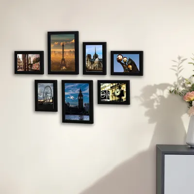 A collection of seven framed pictures of landmarks displayed on a white wall.