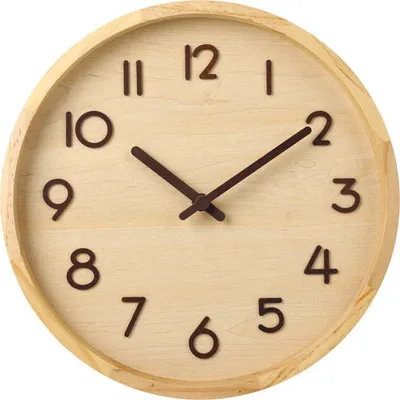 A close-up, front-facing view of a round, wooden wall clock with dark brown hour markers and hands.
