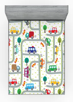 A flat lay of a fitted sheet with a car-themed pattern, laid out on a bed frame.