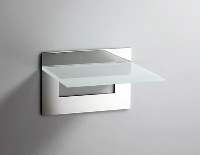 A modern glass shelf with a polished stainless steel frame mounted on a gray wall.