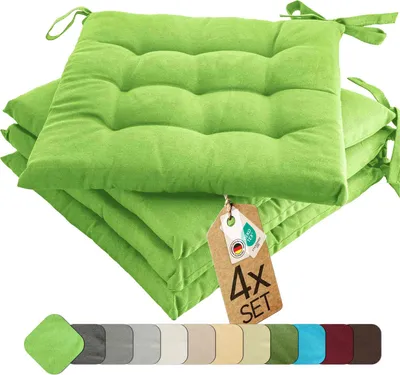A stack of four green seat cushions with ties, displayed on a white background. A product tag is attached to the top cushion.