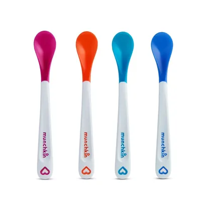 Four baby spoons of different colors arranged in a row against a white background.