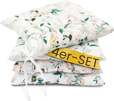 A stack of four floral-patterned seat cushions tied together with a white ribbon.