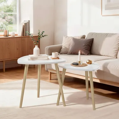 A living room scene with two nesting coffee tables in the foreground, a sofa and a cabinet in the background.