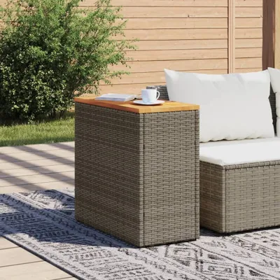 An outdoor patio scene with a rattan side table and a cushion on a sofa.