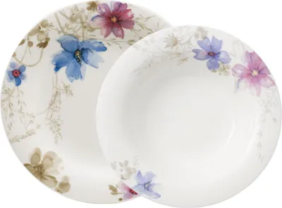 A close-up shot of two white plates with a floral design.