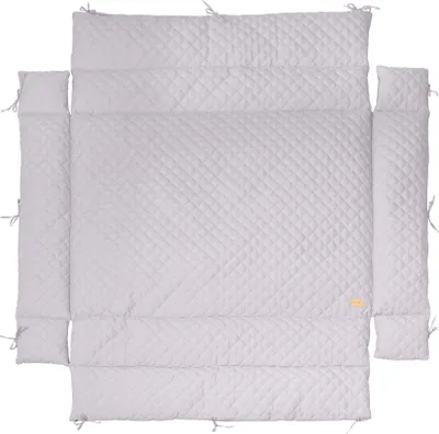 A quilted baby crib bumper pad laid out flat on a white background.