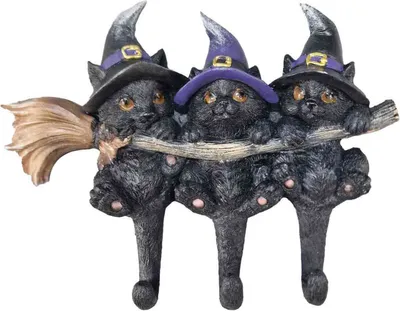 Three black cats wearing witch hats are hanging from a branch, with a broomstick on the left.