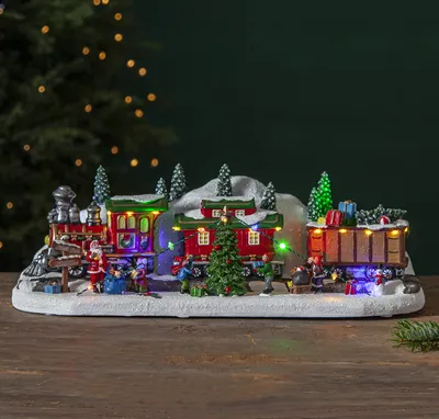 A festive Christmas train scene with Santa and elves.