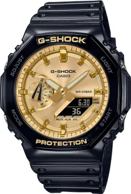 A close-up studio shot of a black and gold G-Shock watch against a white background.