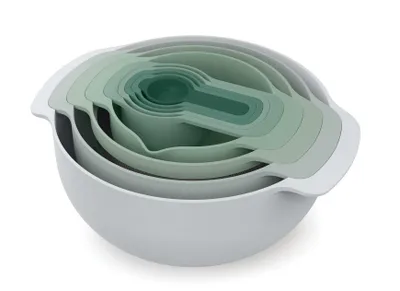 A set of nesting mixing bowls and measuring cups in various shades of green and gray, stacked together.