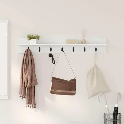 A white shelf with hooks mounted on a light-colored wall, displaying various items like a scarf, a handbag, keys, a decorative plant, and a box.