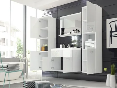 A modern white bathroom vanity set with a mirror, sink, and storage cabinets, set against a dark tiled wall and a large window.