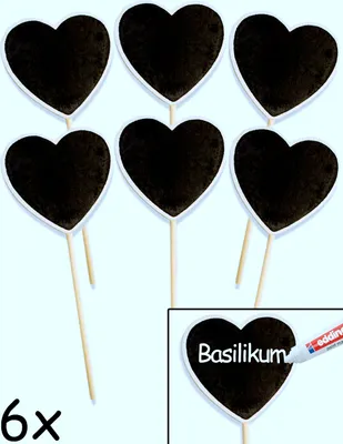 Six heart-shaped plant markers on wooden sticks, with one marker showing the word 'Basilikum' written on it.