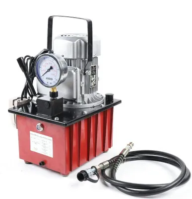 A hydraulic electric pump with a pressure gauge and hose, isolated on a white background.