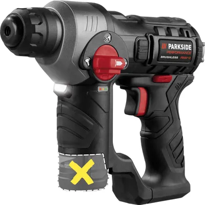 A black and gray cordless hammer drill with red accents is shown against a white background. The drill has a white LED light near the front and a red rotary switch on top. A yellow 'X' symbol is overlaid on a grayed-out section at the bottom of the handle,