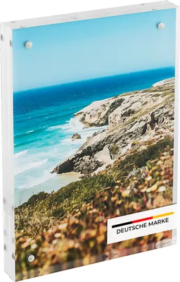 A clear acrylic photo frame displaying a scenic coastal image, with a German brand label at the bottom.