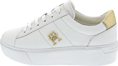 A side view of a single white Tommy Hilfiger platform court sneaker with gold accents.