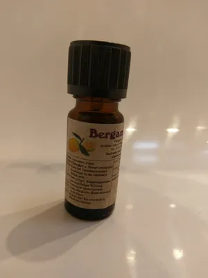 Kleine braune Flasche mit einem schwarzen Verschluss. Auf dem Etikett steht "Bergamotte".