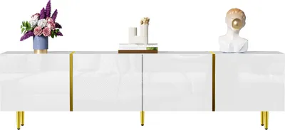A white TV stand with gold accents and legs, decorated with a vase of flowers and a bust sculpture.