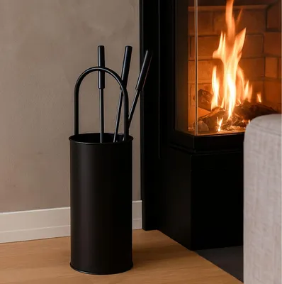 A fireplace set with tools in a holder next to a burning fireplace.