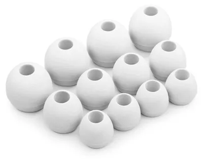 A collection of white silicone earbud tips of various sizes arranged on a white background.