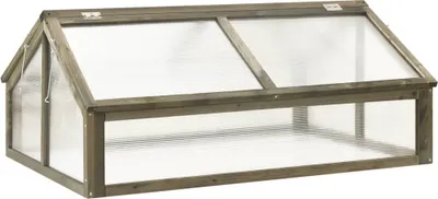 A wooden cold frame greenhouse with a clear plastic lid.