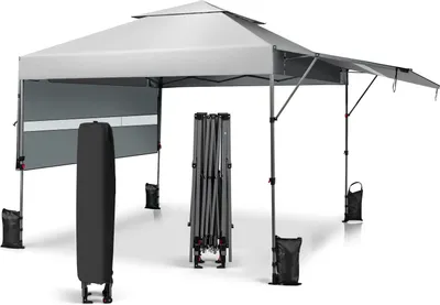 A pop-up gazebo with its frame folded and a storage bag next to it, along with sandbags for stability.