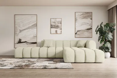 A modern living room with a beige sectional sofa, abstract art on the wall, and a large potted plant.