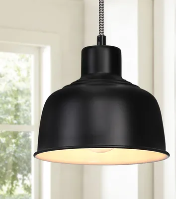 A black pendant light hangs in front of a window.